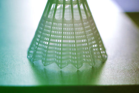 Close-Up of White Plastic Badminton Shuttlecock with Green Light Reflectionの写真素材