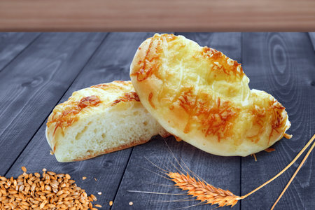 Freshly Baked Cheese Bread Rolls with Wheat on Wooden Tableの写真素材