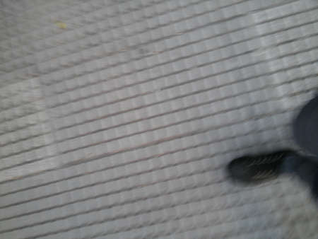 Background of feet with black shoes walking of a sidewalk with different elements in daylightの写真素材