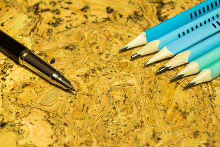 Fountain pen and pencils on textured cork table. A textured background.Copy paste placeの写真素材