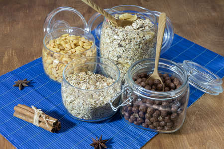 Muesli, granola, cereal and nuts in a glass container on a wooden table. Rustic food.の写真素材