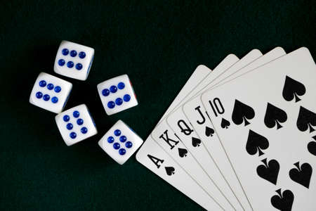 White bones thrown on the table, a Royal flush of spades. Dark green clothの写真素材