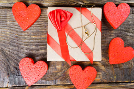 The gift is Packed in Kraft paper and tied with a red ribbon with a rose in the shape of clogs with briliant.の写真素材