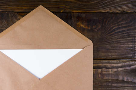 Envelope nested in it leaves lying on vintage wooden table. A place for your inscriptions.の写真素材