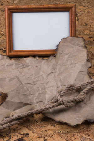 Part of the old burnt parchment and a knot of hemp rope lying on the Old wooden table. A place for your inscriptionsの写真素材
