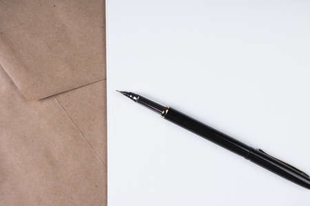 Sheets of blank paper lying on the envelope. The fountain pen is opened and ready for writing of the text. A place for your inscriptionsの写真素材