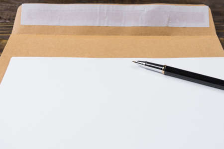 Sheets of blank paper lying on the envelope. The fountain pen is opened and ready for writing of the text. A place for your inscriptions.の写真素材