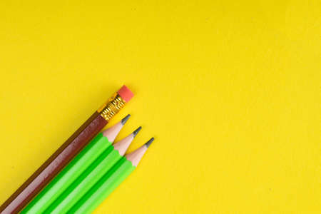 Business concept - lot of same pencils and one different pencil on yellow paper background. Copy pasteの写真素材