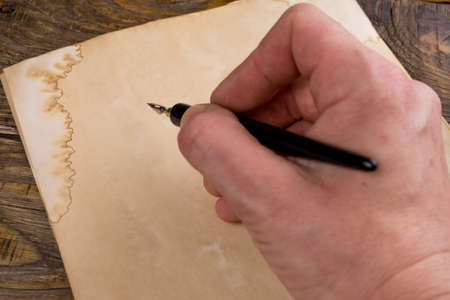 Mock up. Hand writing with old quill pen on the old paper. Empty place for a text. Copy space.の写真素材