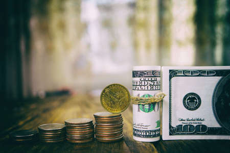 One hundred dollars banknotes of the stack of coins from quarters and one dollar. Copy pasteの写真素材