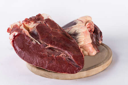 Beef heart cut in half on a cutting board. isolate on white background. copy spase.の写真素材