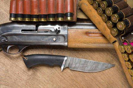 Hunting rifle and ammunition lie on a wooden backgroundの写真素材