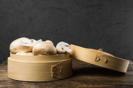 A round container of white mushrooms on table.の写真素材
