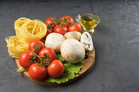 Mushrooms mushrooms, lettuce, tomatoes and spaghetti on tableの写真素材
