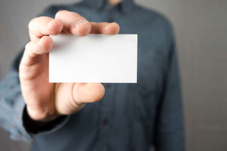 Businessman holding a business card. Mock up.