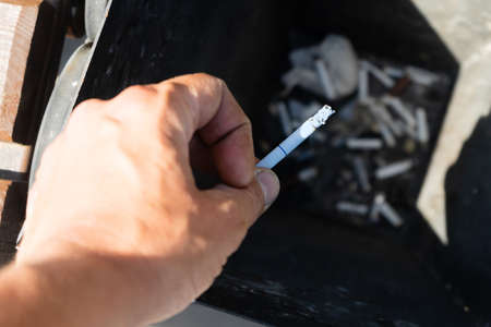 Smoking a cigarette, hand finishing a cigarette in an ashtray. Close up