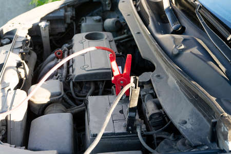 A Car battery Jumper Cables with copper clamps attached to the terminals.