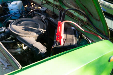 A Car battery Jumper Cables with copper clamps attached to the terminals.