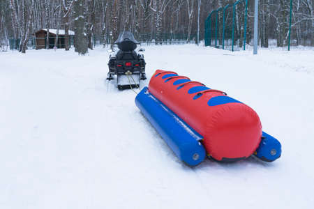 Snowmobile and inflatable sledの写真素材
