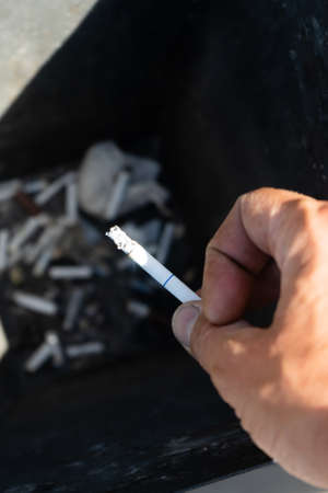 Smoking a cigarette, Hand finishing a cigarette in an ashtray.