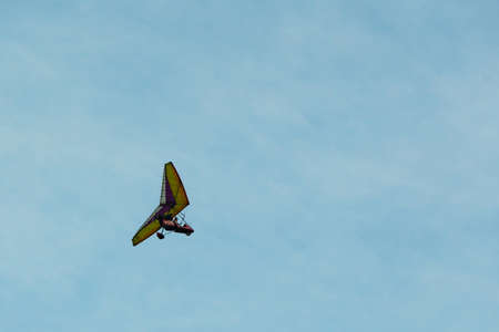 The hang-glider on a background blue sky with light clouds. Flying a gyroplane. Copy space.の写真素材