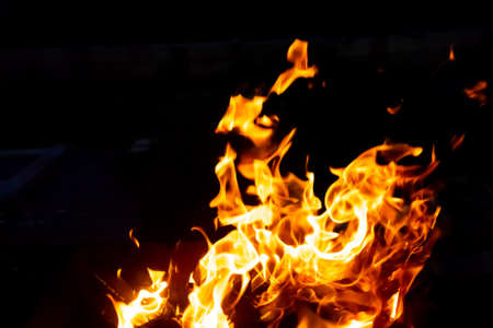 Flames of fire from burning coals in the grill late at night. Copy paste.