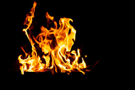 Flames of fire from burning coals in the grill late at night.の写真素材