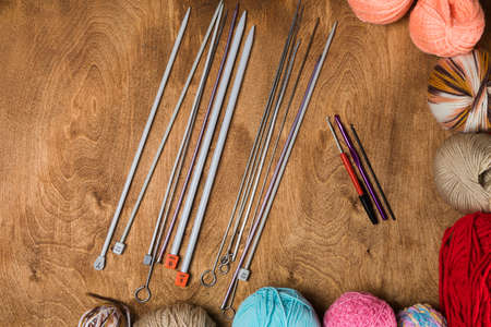 Closeup of knitting needles with balls of yarn in different colorsの写真素材