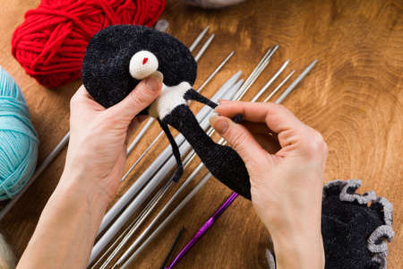 A woman knits a wool toy with hook. Hands close-up.の写真素材