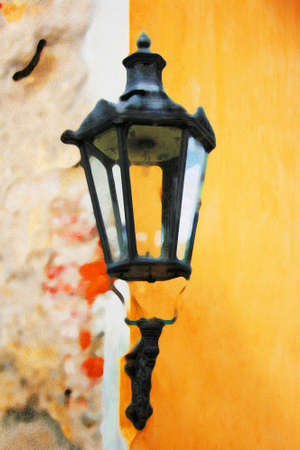 Ancient lantern on the textured wall shines with warm lightの写真素材