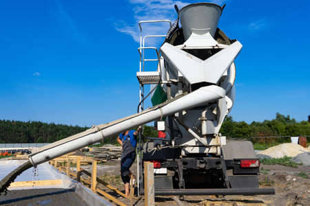 Workers pour the Foundation for the construction of a residential building using mobile concrete mixers. Copy pasteの写真素材