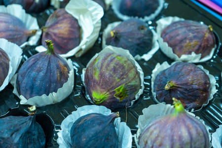 Figs in a paper containers are put up for sale on fruit market.の写真素材
