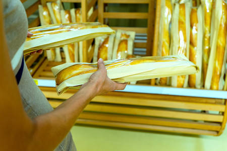 Woman selecting loaf of bread at supermarket.の写真素材