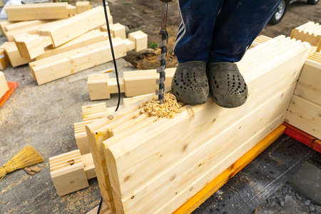 Drilling holes in laminated veneer lumber for shkantov. Construction of the house from the profiled glued bar.の写真素材