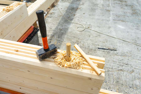 Construction of the house from a bar. Drilling holes and clogging of dowels.の写真素材