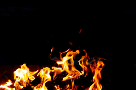 Flames of fire from burning coals in the grill late at night. Copy paste.