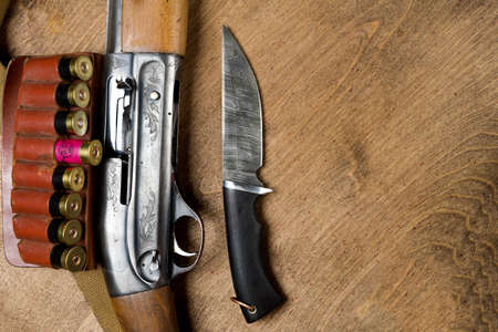 Hunting rifle and ammunition lie on wooden background.の写真素材