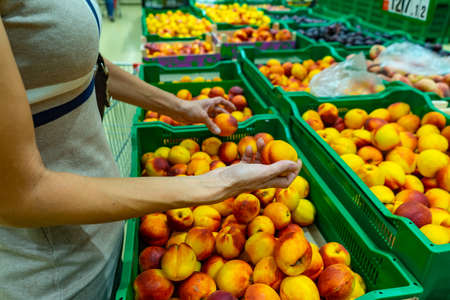Woman hand choosing vegetable in supermarket. Healthy foodの写真素材