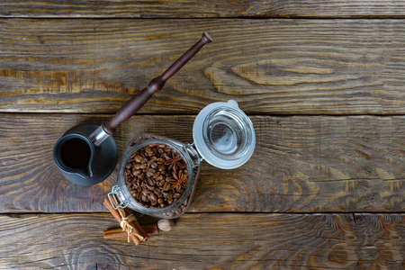 Cezve and roasted coffee beans in box on a rustic table, cinnamon and dried lemonの写真素材