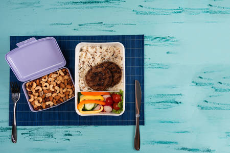 Lunch box with appetizing food and on light wooden tableの写真素材