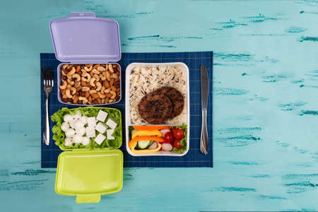 Lunch box with appetizing food and on light wooden tableの写真素材
