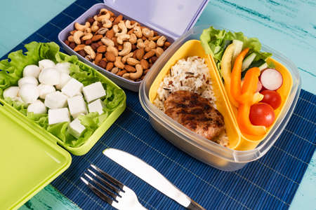 Lunch box with appetizing food and on light wooden tableの写真素材