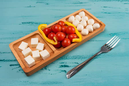 Cheese compartmental dish with different cheeses, on rustic wooden backgroundの写真素材