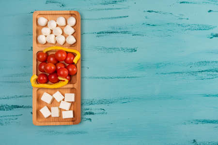 Cheese compartmental dish with different cheeses, on rustic wooden backgroundの写真素材