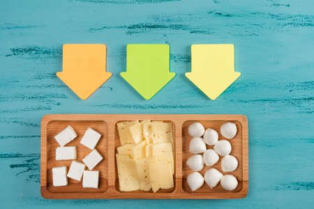 Cheese compartmental dish with different cheeses, on rustic wooden backgroundの写真素材