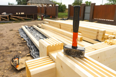 Construction of the house from a bar. Drilling holes and clogging of dowelsの写真素材