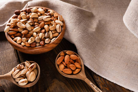 Assortment of nuts in wooden bowl on dark wooden table.の写真素材