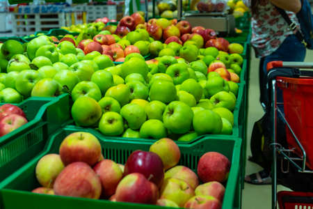 Bunch of green and red apples on boxes in supermarketの写真素材