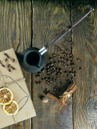 Cezve and roasted coffee beans in box on a rustic table, cinnamon and dried lemon.の写真素材