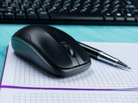 Office table desk. Workspace with blank note book, keyboard, office supplies, on wooden background.の写真素材